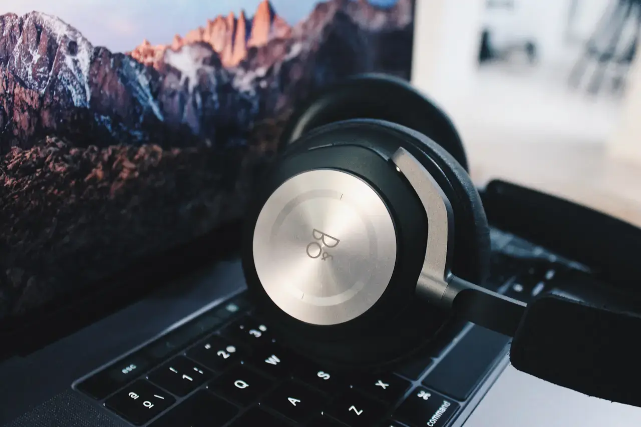 Over-ear headphones resting on a laptop.